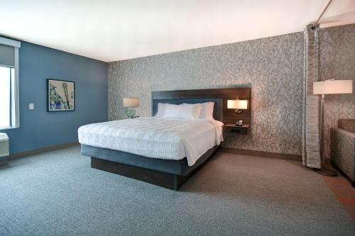 a bedroom with a large bed with blue walls at Home2 Suites by Hilton Las Vegas Convention Center - No Resort Fee in Las Vegas
