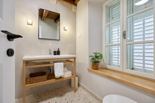 ein Badezimmer mit Waschbecken und Spiegel in der Unterkunft Modern Stone House, luxury suites in Dubrovnik Old Town in Dubrovnik