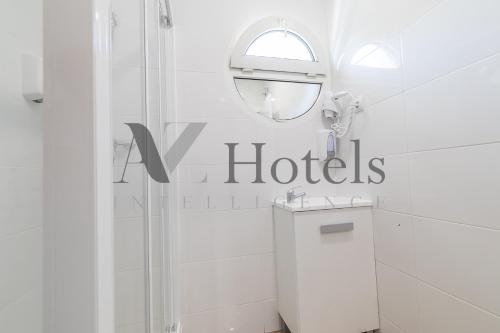 a white bathroom with a shower and a mirror at AYZ Joaquín Pol - Auto check-in property in Madrid