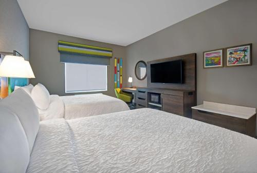 a hotel room with two beds and a flat screen tv at Hampton Inn Las Vegas Strip South, NV 89123 in Las Vegas