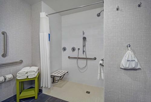 a bathroom with a shower and a bench in it at Hampton Inn Las Vegas Strip South, NV 89123 in Las Vegas