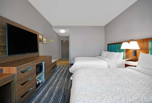 a hotel room with two beds and a flat screen tv at Hampton Inn Las Vegas Strip South, NV 89123 in Las Vegas