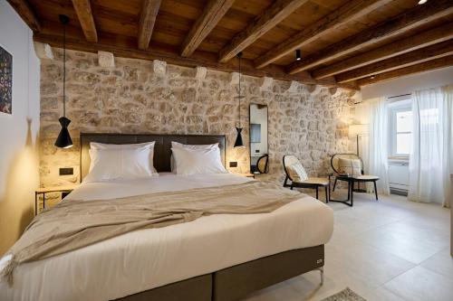 um quarto com uma cama grande e uma parede de pedra em Modern Stone House, luxury suites in Dubrovnik Old Town em Dubrovnik