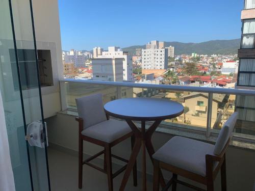- Balcón con vistas, mesa y 2 sillas en Apto novo e bem localizado em Porto Belo - SC, en Porto Belo