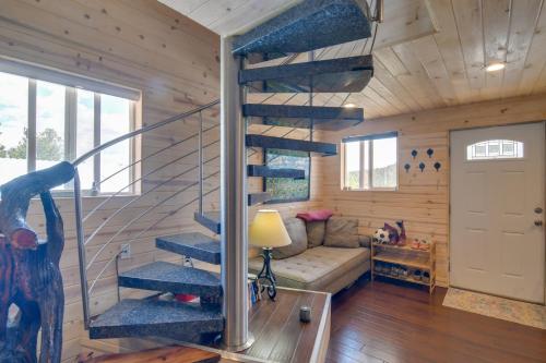 a living room with a spiral staircase in a log cabin at Secluded Jefferson Cabin with Deck and Mountain Views! in Bordenville