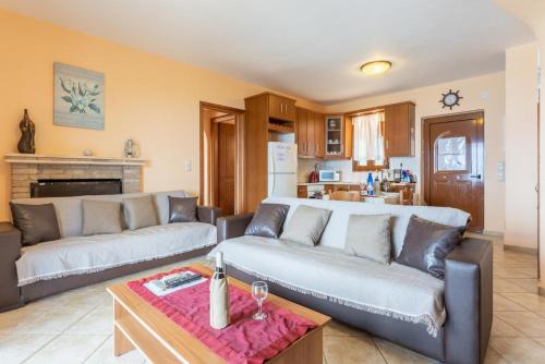 a living room with two couches and a table at Fiscardo Villas Collection in Mesovoúnia