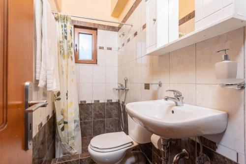 a white bathroom with a sink and a toilet at Fiscardo Villas Collection in Mesovoúnia
