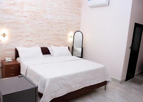 a bedroom with a large bed and a brick wall at HOTEL MAVILLA Cotonou in Cotonou