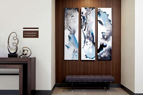 four paintings on a wall in a living room at Embassy Suites Los Angeles - International Airport/North in Los Angeles