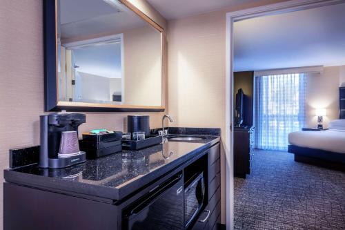 Cette chambre comprend un lavabo et un lit. dans l'établissement Embassy Suites Los Angeles - International Airport/North, à Los Angeles