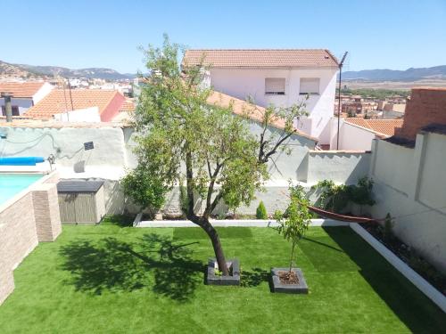 a garden with a tree in the middle of a yard at Casa Oasis Puertollano, una casa rural en Puertollano, agradable, con Piscina en zona tranquila in Puertollano