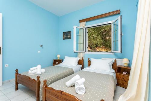 two beds in a room with a window at Villa Evie in Nisaki