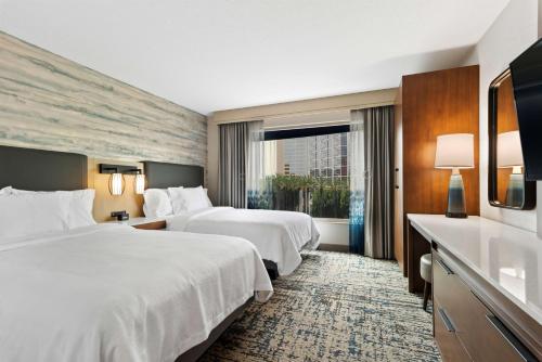 a hotel room with two beds and a window at Embassy Suites by Hilton Anaheim South in Anaheim