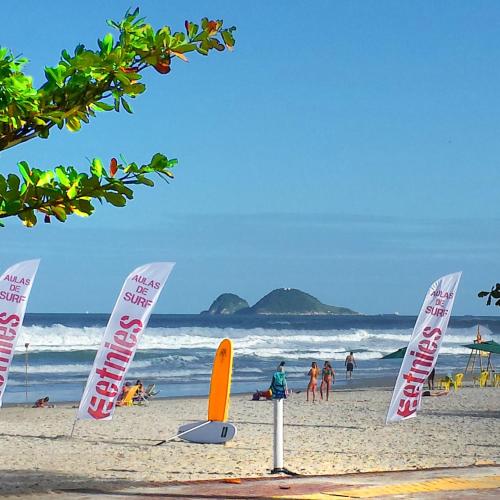 a group of signs on a beach with the ocean at Dom Pedro 55 in Guarujá