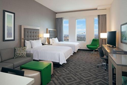 Cette chambre comprend deux lits et une télévision. dans l'établissement Homewood Suites By Hilton Los Angeles International Airport, à Los Angeles