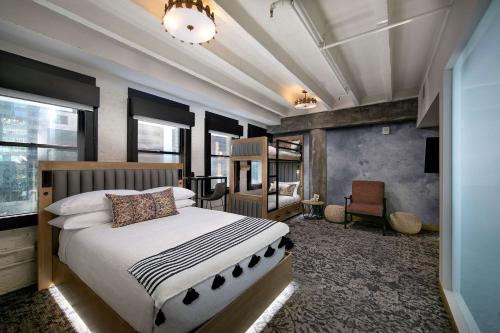 a bedroom with a large bed and a chair at The Wayfarer Downtown LA, Tapestry Collection by Hilton in Los Angeles
