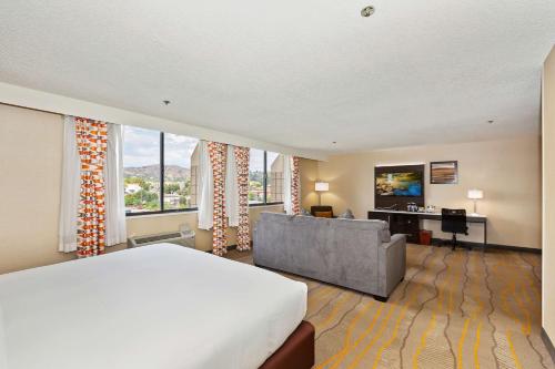a hotel room with a bed and a couch at Doubletree by Hilton Whittier in Whittier