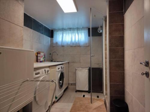 a kitchen with a washing machine and a shower at 90 m2 charmig källarlägenhet nära natur och stad in Mölndal