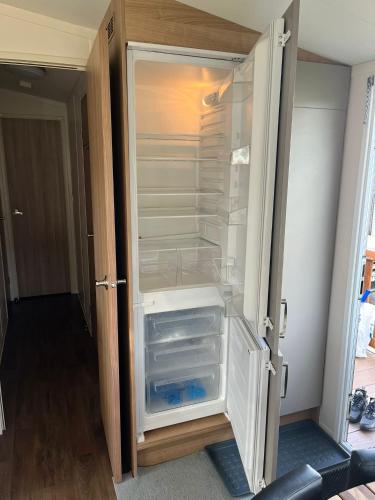 an empty refrigerator with its door open in a room at The Luxury break Sleeps 6 at Kingfisher Court South facing in Tattershall