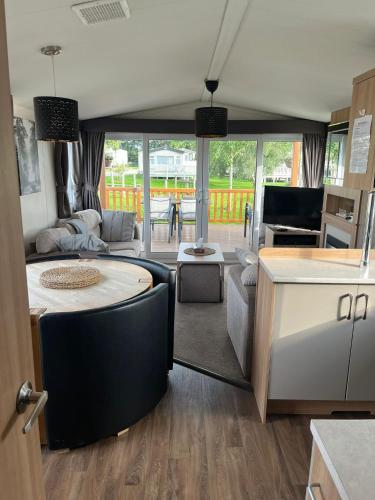a kitchen and living room with a table and a couch at The Luxury break Sleeps 6 at Kingfisher Court South facing in Tattershall