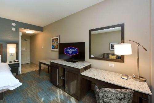 a hotel room with a vanity and a mirror at Hampton Inn Lumberton, NC in Lumberton