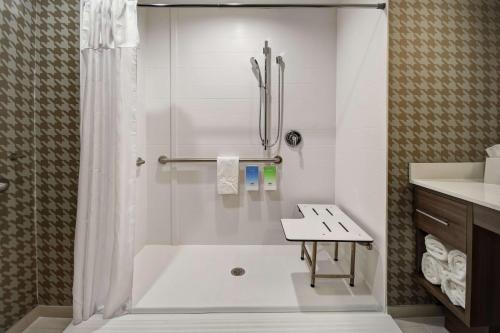 Home2 Suites By Hilton Columbus Downtown في كولومبوس: حمام أبيض مع دش ومغسلة