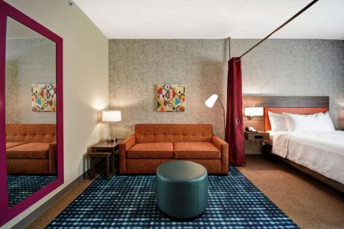 una camera d'albergo con letto, divano e specchio di Home2 Suites By Hilton Columbus Downtown a Columbus