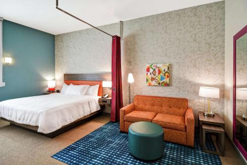 a hotel room with a bed and a chair at Home2 Suites By Hilton Columbus Downtown in Columbus