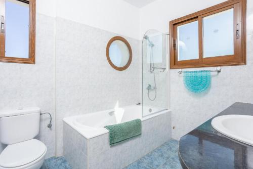 ein Badezimmer mit einem WC, einem Waschbecken und einem Spiegel in der Unterkunft Blue Bay Villas Collection in Mavroli