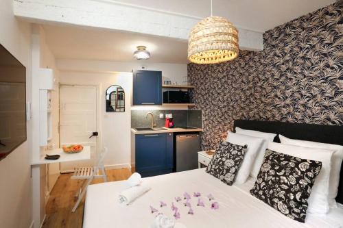 mały apartament z białym łóżkiem i kuchnią w obiekcie La Tour de Bohémond w Carcassonne