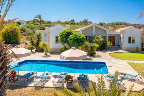 a villa with a swimming pool and a house at Villa Amorosa in Neo Chorio