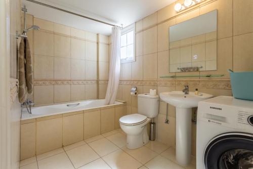 新喬里歐的住宿－Villa Amorosa，浴室配有卫生间、盥洗盆和洗衣机。