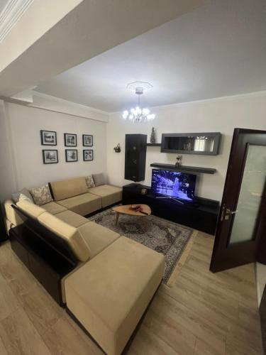 a living room with a couch and a tv at Dream House Korça in Korçë