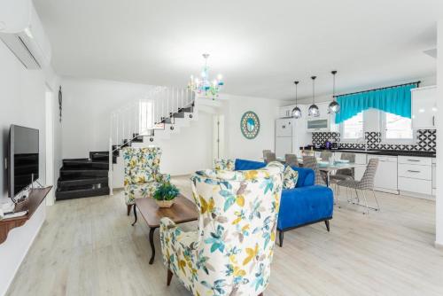 a living room and kitchen with a blue couch and chairs at Villa Portakal Blossom in Dalyan