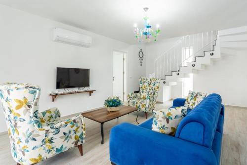 a living room with blue chairs and a blue couch at Villa Portakal Blossom in Dalyan