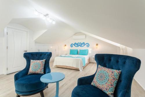 een slaapkamer met een bed en 2 stoelen en een tafel bij Villa Portakal Blossom in Dalyan