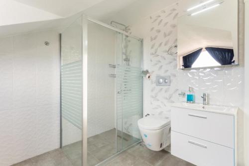 een witte badkamer met een douche en een toilet bij Villa Portakal Blossom in Dalyan