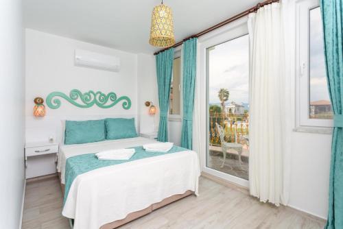 a bedroom with a bed and a large window at Villa Portakal Blossom in Dalyan