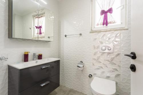 a bathroom with a sink and a toilet and a mirror at Villa Portakal Blossom in Dalyan