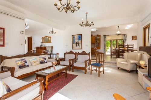 a living room filled with furniture and a chandelier at Villa Xenios Dias in Argaka