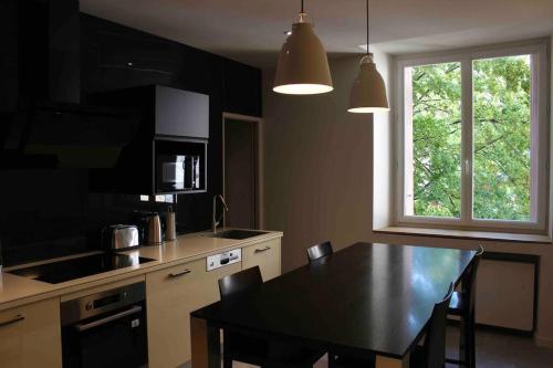 une cuisine avec une table noire et une fenêtre dans l'établissement Le Grenoblois - Hypercentre, à Grenoble