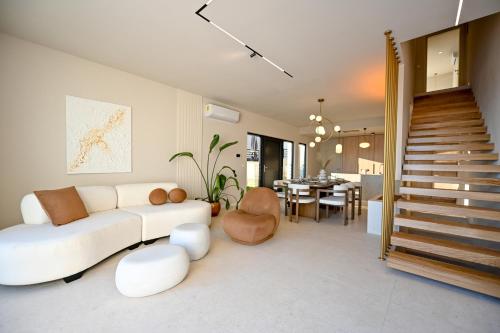 a living room with a white couch and a staircase at Villa Rosemary West in Makarska