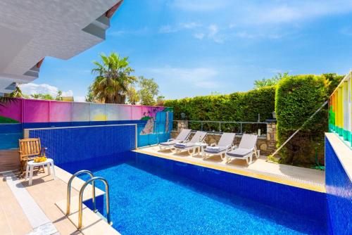 a swimming pool with lounge chairs next to a house at Villa Ayla Paradise in Dalyan