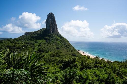 a rock formation on a hill next to the ocean at Hamares Boutique Hotel in Fernando de Noronha