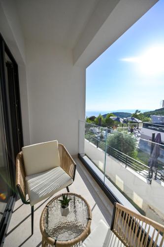 a balcony with a chair and a table and a large window at Villa Rosemary West in Makarska