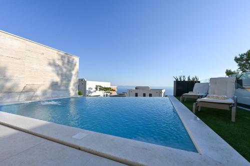 a swimming pool on the roof of a house at Villa Rosemary West in Makarska