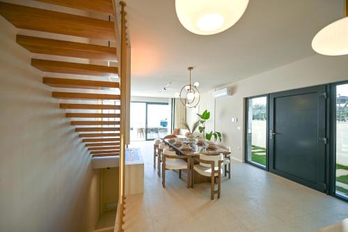 a dining room with a table and a staircase at Villa Rosemary West in Makarska