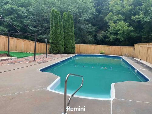 a swimming pool in a yard with a fence at Home away from home! in Canton