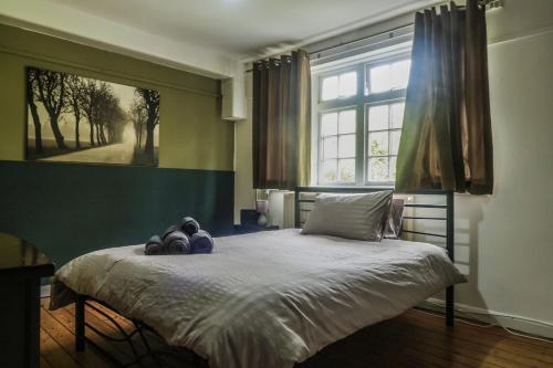 a bedroom with a bed with a large window at Vintage Room-Only Room in London