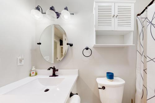 La salle de bains blanche est pourvue d'un lavabo et d'un miroir. dans l'établissement Cozy Family Home, à Penn Yan